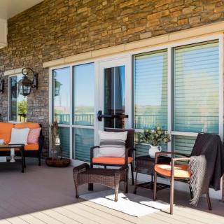A cozy patio setup with outdoor furniture against a stone wall.