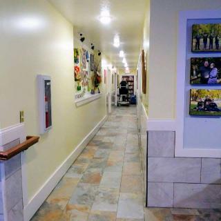 A brightly lit hallway adorned with various artworks along the walls.