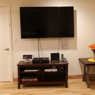 A modern living room setup featuring a wall-mounted television above a stylish entertainment center.