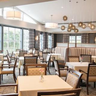 A well-lit dining area featuring modern furniture and elegant lighting.