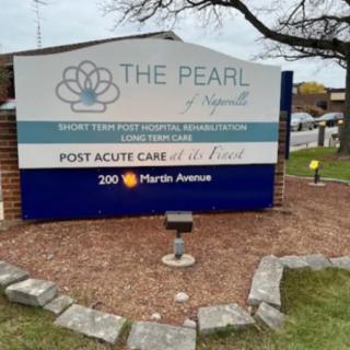 A sign outside of a healthcare facility named 'The Pearl' indicating it provides post acute care, located at 200 Mariah Avenue.