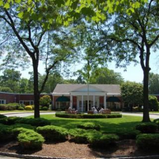 A charming building surrounded by lush greenery on a sunny day.