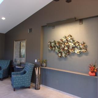 A stylish lobby area featuring modern decor with blue chairs and wall art.