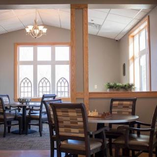 A spacious and elegantly designed dining area with natural light filtering through large windows.