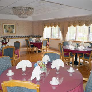 An elegantly arranged dining room with tables set for a formal meal.