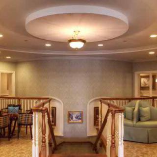 A cozy interior space featuring a staircase, seating area, and elegant lighting.