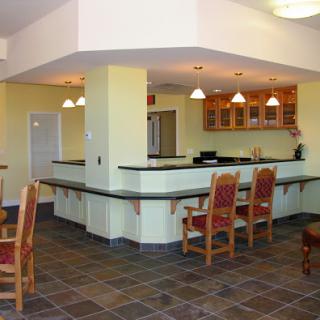 A spacious and modern kitchen bar area with seating, featuring a vibrant color palette and stylish fixtures.