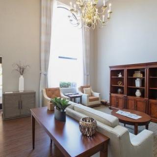 A well-furnished living room with a chandelier, sofa, and bookshelf.
