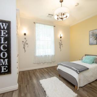 A cozy and minimalistic bedroom with a single bed, featuring wooden floors and a welcoming atmosphere.