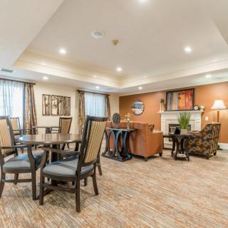 A cozy and well-lit seating area featuring tables, chairs, and comfortable furniture.