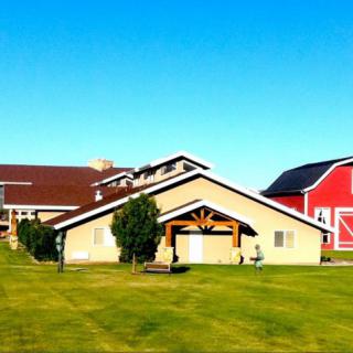 A picturesque rural scene featuring a barn and farm buildings under a clear blue sky.