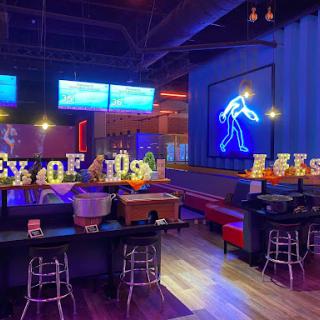 A vibrant and modern bar scene with neon accents and lounge seating.