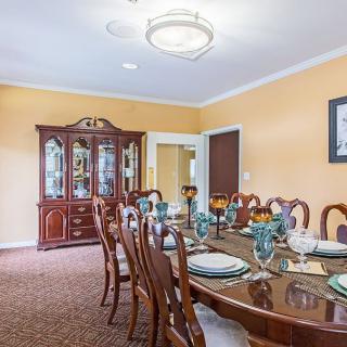 A beautifully set dining room with elegant furniture and a chandelier.