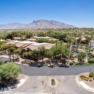 Aerial view of a residential area with mountains in the background and a clear blue sky.