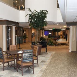 A spacious lobby area with a seating arrangement and indoor plants.