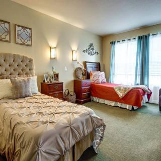 A cozy bedroom with twin beds, bedside tables, and warm lighting.