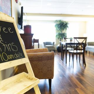 A cozy lounge area with comfortable seating and a chalkboard sign.