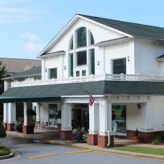 A large residential building with a front porch and multiple windows.