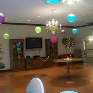 A decorated indoor space with colorful balloons and a chandelier.