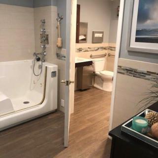 A modern bathroom featuring an accessible bathtub and toilet.