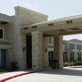 A modern building with a stone facade and a covered entrance.