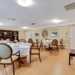 A well-lit dining room with neatly arranged tables and chairs.