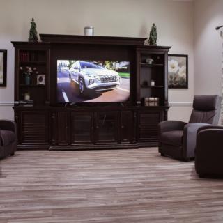 A cozy living room setup featuring a large entertainment center with a TV and comfortable recliners.