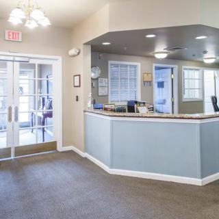 A modern reception area with a desk and seating, featuring bright lighting and a clean design.