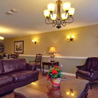 A cozy living room with leather sofas, a wooden coffee table, and elegant lighting fixtures.