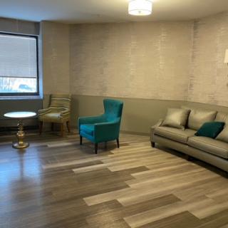 A spacious and modern living room featuring a comfortable sofa, stylish chairs, and elegant decor.