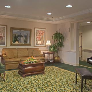A cozy lobby with a sofa, coffee table, and decorative plants.