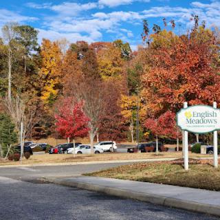 A picturesque autumn scene featuring vibrant fall foliage and a welcoming entrance sign.