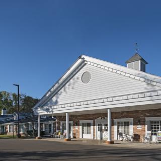 A residential building with a porch and columns under a clear blue sky.
