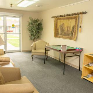 A cozy waiting area featuring comfortable chairs, a small table, and decorative elements.