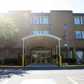 A commercial building entrance with an awning and a flag displayed outside during daylight.