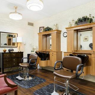 Interior view of a barbershop with chairs and mirrors.