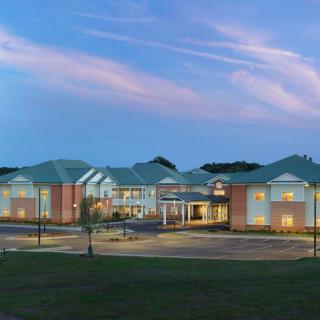 A view of a modern building during the evening with a picturesque sky.