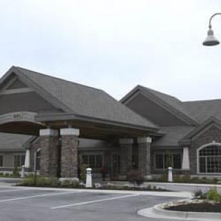 A commercial building with a stone facade and a parking area.