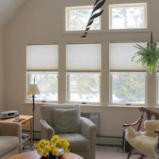 A cozy living room with comfortable armchairs and ample natural light from large windows.