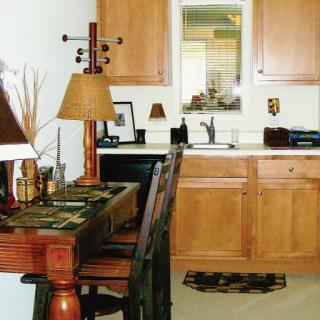A cozy kitchen and dining area featuring wooden cabinets, decorative lamps, and a welcoming atmosphere.