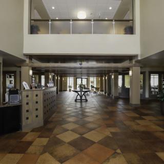A spacious and modern lobby with a checkered floor and reception area.
