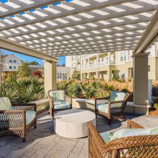 A cozy outdoor seating area under a pergola, perfect for relaxing and enjoying the surroundings.