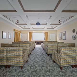 A well-designed conference room with comfortable seating and a projector for presentations.