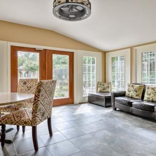 A bright and inviting dining and living area with ample natural light, featuring modern furniture and large windows.