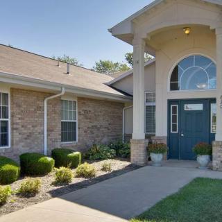 A well-maintained building entrance with neatly trimmed bushes and a welcoming pathway.