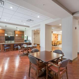 A modern dining area with wooden floors, tables, and chairs.