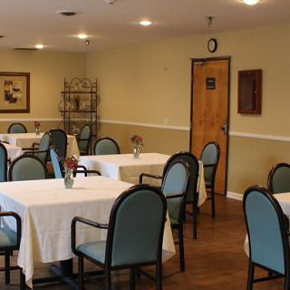 An empty dining room with neatly arranged tables and chairs, ready for guests.