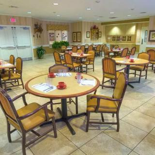 A well-lit dining area with several tables and chairs arranged neatly.