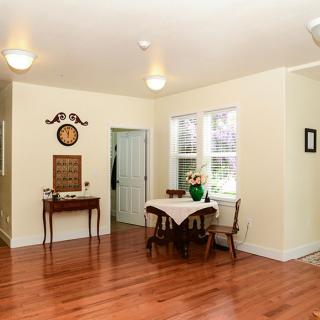 A cozy dining area with a small table, chairs, and wall decor on a hardwood floor.