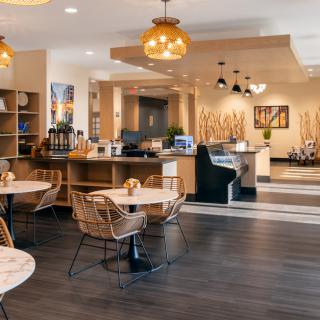 A cozy coffee shop with modern interior design, featuring comfortable seating and warm lighting.